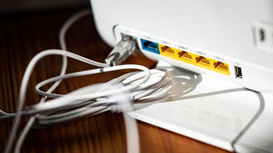 Ein LAN-Kabel steckt im DSL-Steckplatz eines WLAN-Routers Ein LAN-Kabel steckt im DSL-Steckplatz eines WLAN-Routers