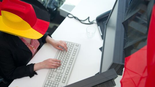 Eine Frau in Fankleidung am Arbeitsplatz