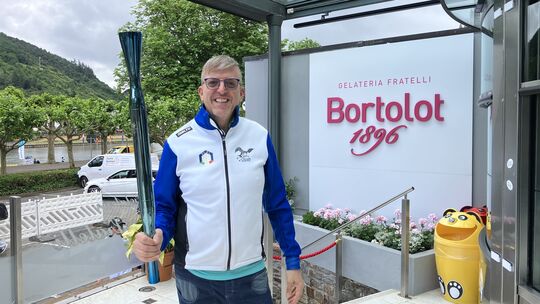 Stolz präsentiert Stefano Bortolot die olympische Fackel. Für die Winterspiele 2026 in Mailand-Cortina wurde er als einer von 10