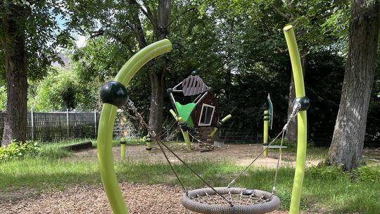 Auf dem Spielplatz in der Kinzingerstraße findet man ein modernes Netzklettergerüst mit Rutsche, eine Vogelnestschaukel, eine Sc