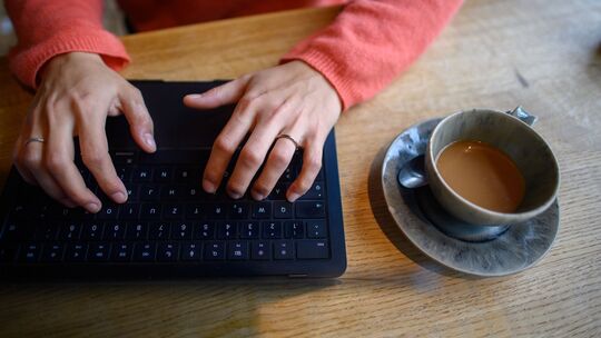 Eine Frau nutzt ihren Laptop in einem Café