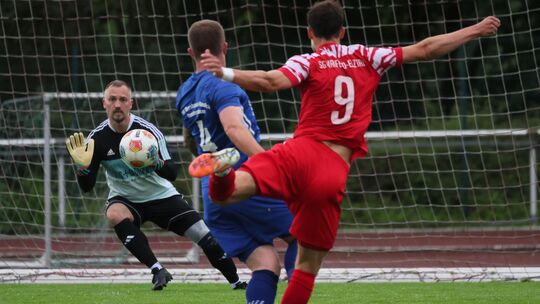 Maifelds Stürmer Niclas Lohn (rotes Trikot) prüft Morshausens Torhüter Danny Menkenhagen.