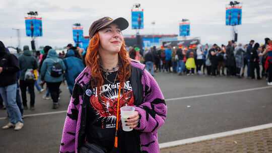 Mariia Isangulova zeigt sich auf dem Festivalgelände - natürlich - mit dem von ihr designten Community-Shirt.