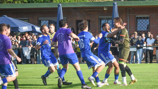 Die Bretzenheimer stürzen auf ihren Matchwinner Niko Benes (rechts) zu, der im Elfmeterschießen drei Roxheimer Versuche parierte