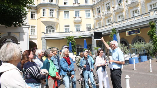 Am Kurhaus zog Hans-Jürgen Sarholz mit Stichen und Fotos Vergleiche zur heutigen Zeit und berichtete von Adligen und Blumenverkä