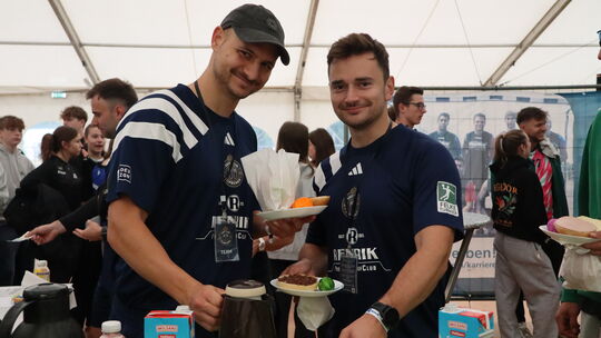 Das HSV-Frühstück kommt gut an: Die beiden Spieler decken sich mit Brötchen, Eiern und Kaffee ein.