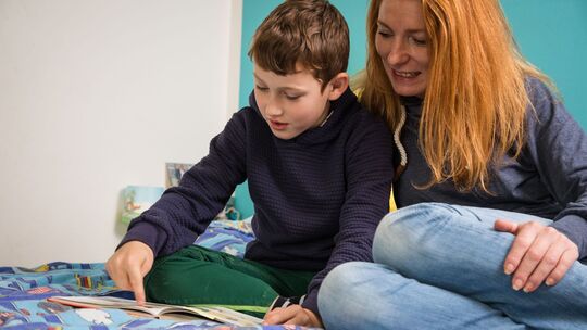 Mutter und Sohn schauen in ein Buch Mutter und Sohn schauen in ein Buch