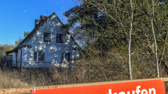 Ein Schild mit der Aufschrift "zu verkaufen" steht auf einem Grundstück mit einem Einfamilienhaus. Die Sparkasse hat ihren jährl