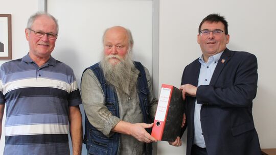 Im Bad Emser Kreishaus haben (von links) Fritz Gerharz und Günter Kläs Landrat Jörg Denninghoff den Ordner mit 588 Unterstriften