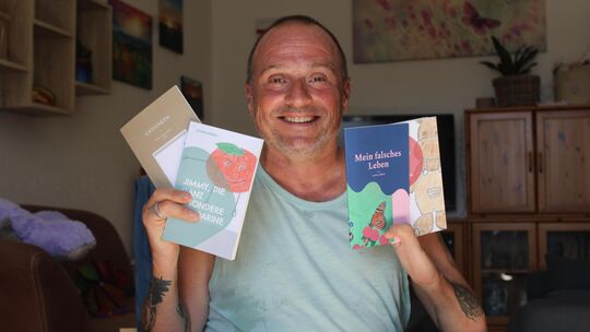 Stolz präsentiert Jochen Hübner die vier kleinen Bücher, die er geschrieben hat. Er wünscht sich, dass sein Leben, in dem seine