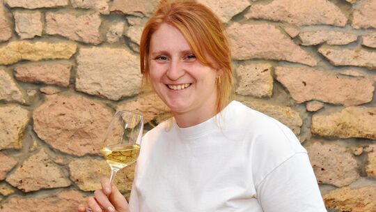 Rebecca Crusius mit ihrem Gutsriesling, der im Jubiläumsjahr ein besonderes Etikett trägt. Rebecca Crusius mit ihrem Gutsriesling, der im Jubiläumsjahr ein besonderes Etikett trägt.