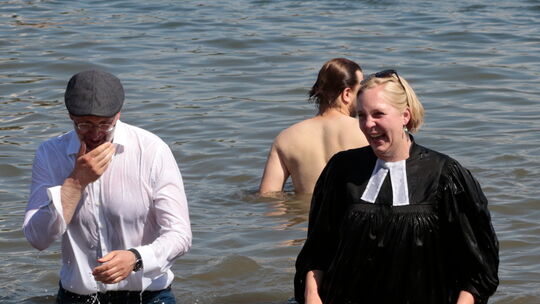 In vollem Ornat stürzen sich die Koblenzer Pfarrerin Marina Brilmayer und Präses Thorsten Latzel am Stattstrand in die Mosel.