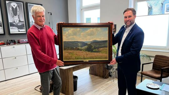 Reinhard Käsinger (links) übergibt das Gemälde "Blick vom Molzberg" an Stadtbürgermeister Johannes Behner.
