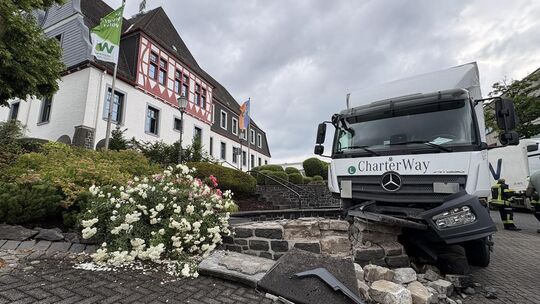 Ein Lkw war auf der Hauptstraße/B54 gegen zwei stehende Pkw (Skoda und VW) geprallt und anschließend in der Brunnenanlage vor de