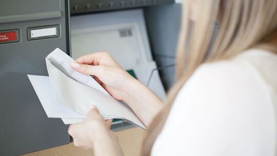 Eine Frau öffnet einen Brief