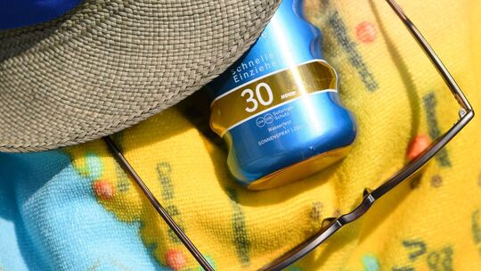 Sonnenspray, eine Sonnenbrille und ein Sommerhut Sonnenspray, eine Sonnenbrille und ein Sommerhut