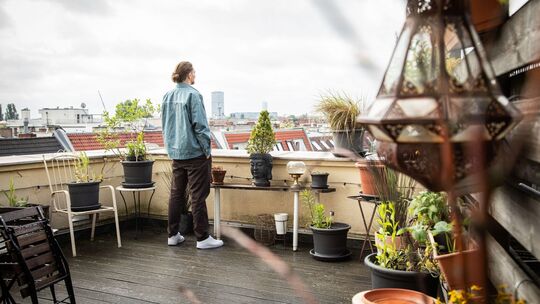 Ein Mann steht auf einer Dachterrasse Ein Mann steht auf einer Dachterrasse