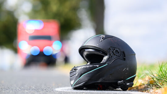 Symbolbild: Der Helm eines Motorradfahrers liegt nach einem Unfall auf der Straße.