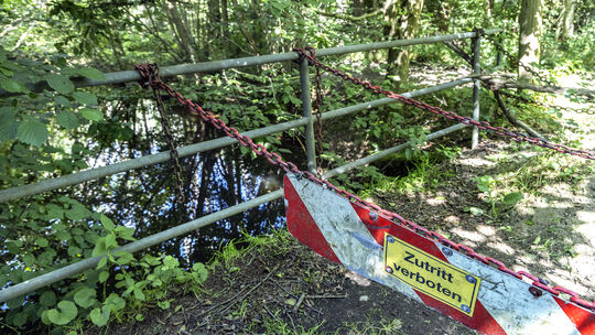 Schwere Eisenketten mit Verbotsschildern versperren die Brücke über den Mühlengraben bei Heuzert. So ist auch der weitere Weg üb