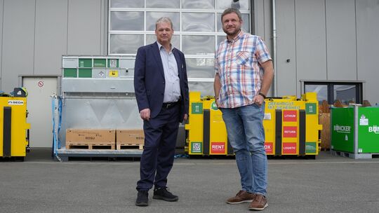 Thorsten Mentges (links) schaut sich zusammen mit Alexander Neubauer die Sicherheits- und Löschboxen für den Batterienversand an