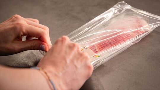 Eine Packung mit Bacon-Streifen wird geöffnet