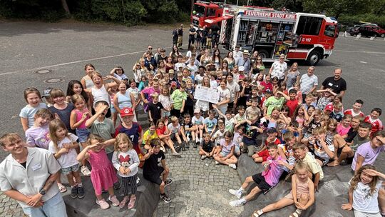 Großer Bahnhof auf dem Kyrau-Schulhof: Die AWO-Ferienkinder und der Vorstand freuen sich über die Spenden von Kreissparkasse und
