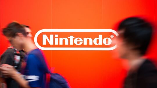 Besucher auf der Gamescom laufen an dem Nintendo-Logo vorbei