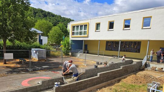 Stein für Stein wächst die neue Rampe am Eingangsbereich. Die Baugruppe arbeitet hier an der barrierefreien Erschließung der Gru
