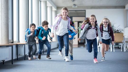 Aufgeregte Schüler rennen durch einen Flur in der Schule