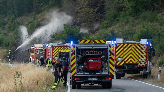 Mit einem Großaufgebot haben die Feuerwehrleute die Brände an der L347 am Donnerstag, 9. Juli, unter Kontrolle gebracht. Nun suc