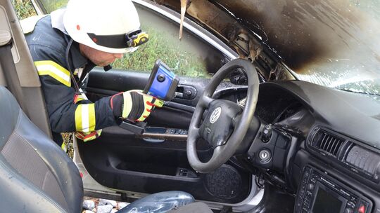 Mit der Wärmebildkamera prüften die Feuerwehrleute in Heilberscheid, ob noch Glutnester im Auto vorhanden waren.
