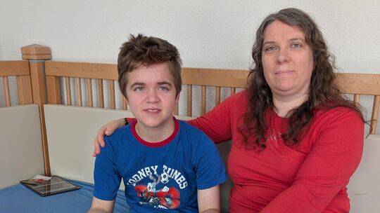 Mutter Stefanie und Sohn Étienne in seinem Zimmer. Hund Davy gehört auch zur kleinen Familie. Der Junge leidet an einer seltenen