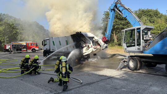 Feuerwehrkräfte bekämpfen den Brand in einem Müllfahrzeug auf der ehemaligen Deponie in Meisenheim.