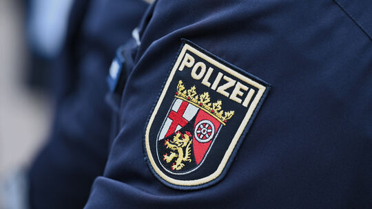 Ein Schulterabzeichen mit der Aufschrift „Polizei“ und dem Wappen des Landes Rheinland-Pfalz ist auf einem Ärmel einer Polizeiun
