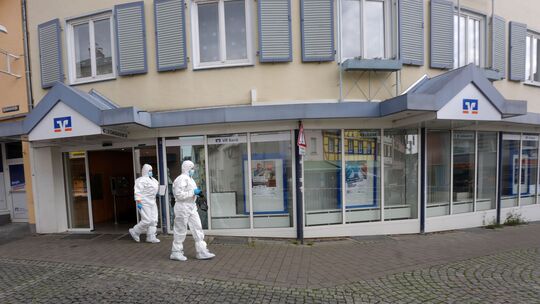 Polizeibeamte durchsuchen nach dem Banküberfall in Sinzig am 8. Mai die Örtlichkeiten.