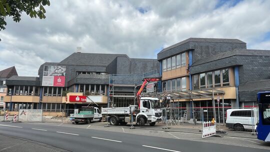 Blick über die Wilhelm-Mangels-Straße in Richtung der ehemaligen Sparkasse: Derzeit werden das Vordach sowie Teile der Fassade z Blick über die Wilhelm-Mangels-Straße in Richtung der ehemaligen Sparkasse: Derzeit werden das Vordach sowie Teile der Fassade z