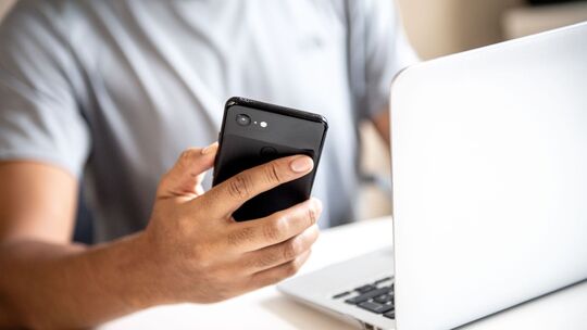 Mann mit Smartphone und Laptop Mann mit Smartphone und Laptop