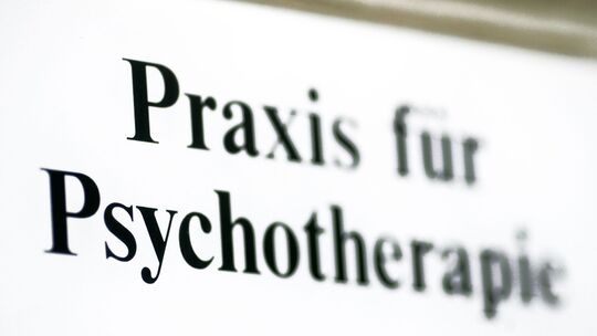 Ein Schild weist auf eine Praxis für Psychotherapie hin