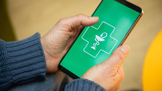Frau hält ein Smartphone mit einer Gesundheits-App in den Händen
