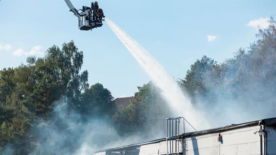 Industriehalle mit Spraydosen in Flammen