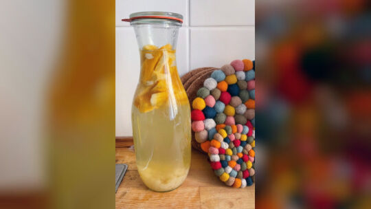 Mangostreifen und Kefirkristalle in einer Flasche mit Wasserkefir