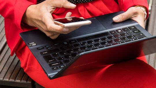 Frau mit Laptop und Smartphone Frau mit Laptop und Smartphone