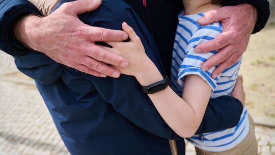Vater umarmt seine beiden Kinder