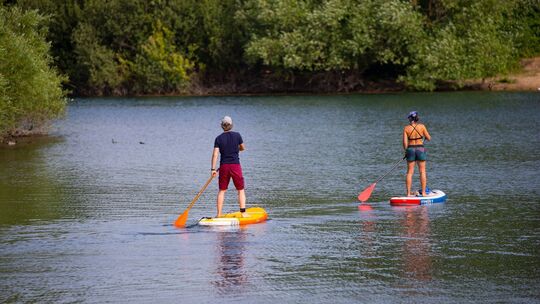 Zwei Stand-Up-Paddler gleiten über den Fühlinger See