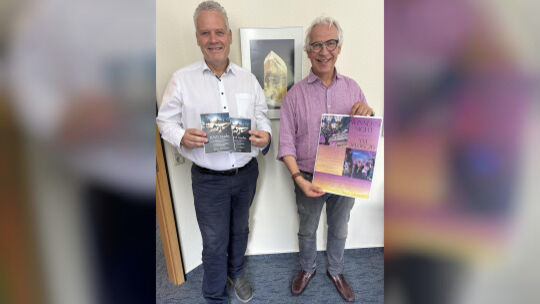 Jörg Lindemann (links) und Paul-Otto Caesar präsentieren die druckfrischen Flyer für die Preisverleihung in der Messe und das Pl