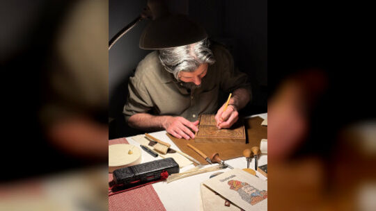 Drucker Jorge Larguito arbeitet an einem Holz-Druckstock