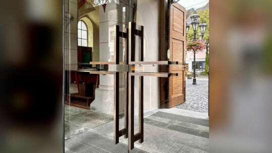 Die Griffe der Türen des neuen Windfanges zeichnen die Form des Kreuzes nach. Ein planerisches Detail des Architekten Andreas Ma