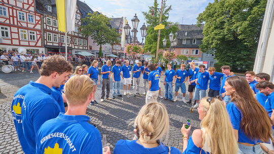 Die Montabaurer Kirmesgesellschaft beim „Einschreien“ unter dem Kirmesbaum vor der Pfarrkirche St. Peter in Ketten.