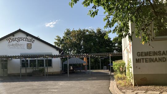 Die Burgschule liegt in ruhiger Lage am Ende einer Stichstraße und hat ihren Namen vom Blick auf den Burgberg, wo einst Kaiser H