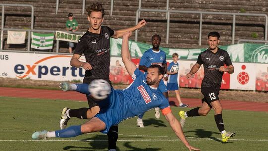 Deniz Darcan liegt quer in der Luft, um das erste Saisontor der SG Eintracht Bad Kreuznach (blaue Trikots) zu erzielen. Die Baum